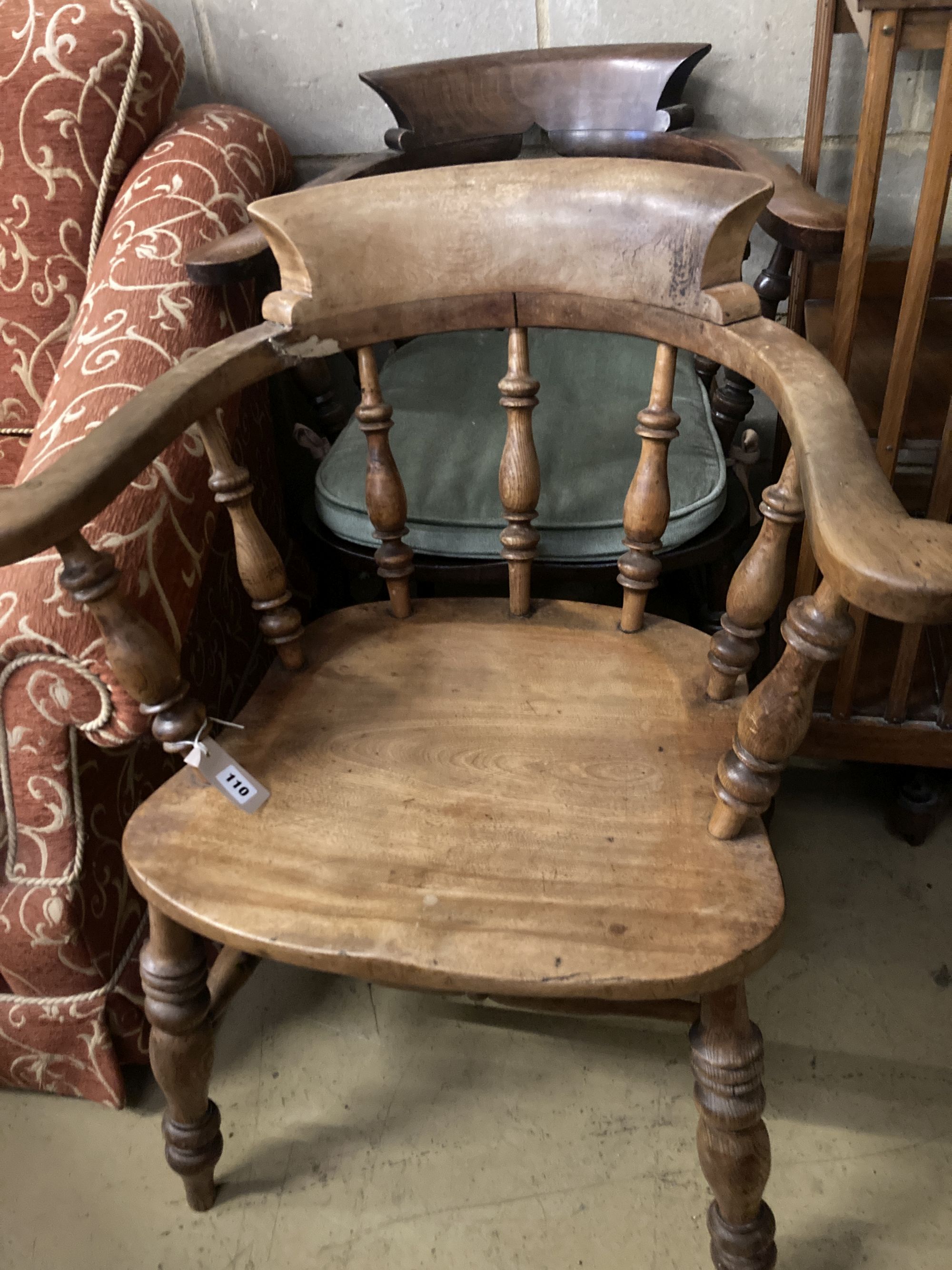 A Victorian smokers bow chair and a similar later chair.